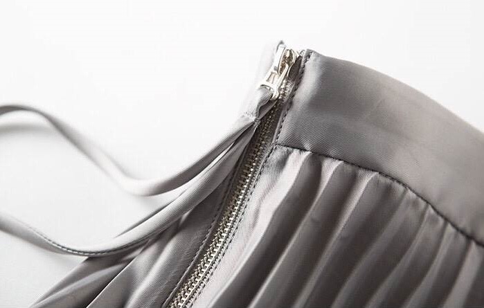 กระโปรงพลีทผ้าไหมเครปซาตินเนื้อดีทรงตรงความยาว 4 ส่วน เป็นกระโปรงทรงเอวสูง ชายกระโปรงยาวเสมอกัน แต่งซิปโลหะสีทองด้านข้าง เหมาะสำหรับใส่ออกงานได้ทั้งงานเช้า มี3 สีสวย