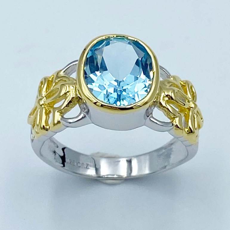 แหวนบลูโทพาส แหวนพลอยเม็ดเดี่ยว แหวนพลอยสีฟ้า ผู้หญิง Sky Blue Topaz OV 10x8 mm สกายบลูโทเพซ เจียรเหลี่ยม รูปไข่ 10x8 มม ด้านข้าวดีไซศ์รูปดอกไม้ งานชุบสองสี