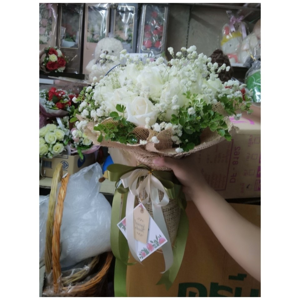 ช่อกุหลาบสีขาวห่อด้วยตะข่ายสีน้ำตาล มอบให้คนรัก