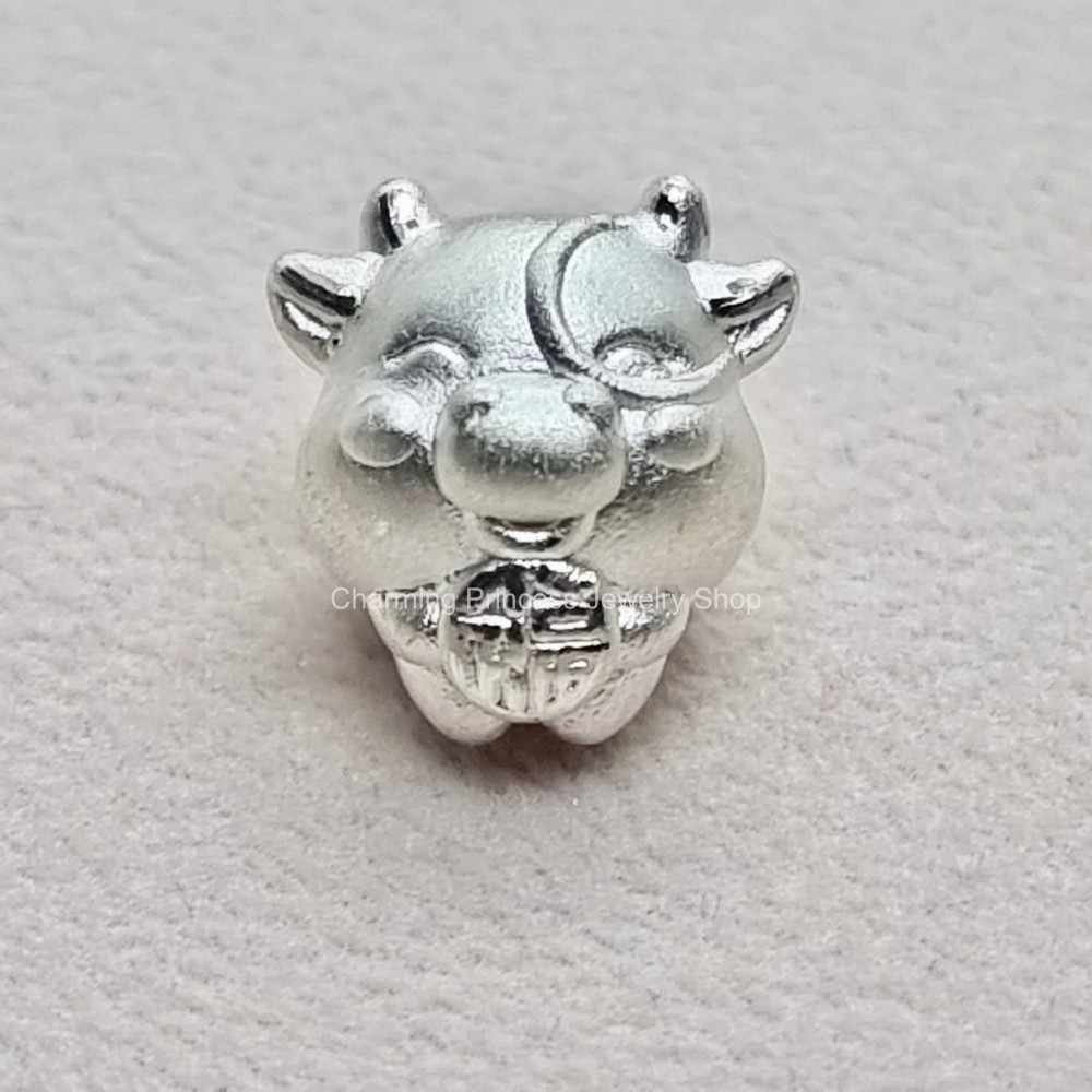 ชาร์มนักษัตรปีฉลู หรือปีวัว เป็นตัวแทนของความอ่อนโยน นุ่มนวล ซื่อตรง รักสงบ มีความกตัญญูรู้คุณ เงินแท้ 99.99% ตัวคั่นสร้อยข้อมือ ชาร์มเงินแท้ 99.99% ขนาด 12x11 มม